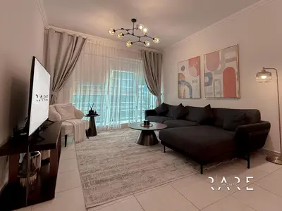 a living room with a couch and a tv at Rare Holiday Homes - Marina Quays West Tower - Near the Beach - R1003 - Dubai Marina in Dubai