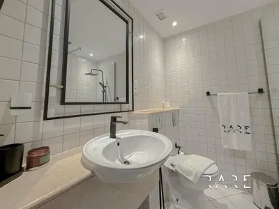 a white bathroom with a sink and a mirror at Rare Holiday Homes - Marina Quays West Tower - Near the Beach - R1003 - Dubai Marina in Dubai