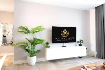 a living room with a tv on a white wall at Damac Waves Tower Dubai Marina - By Home Of Choice in Dubai