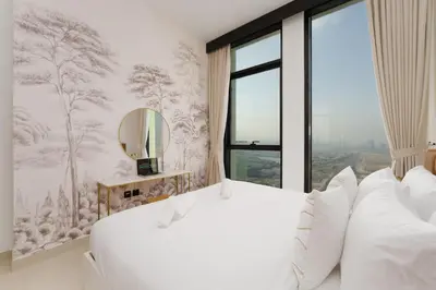 a bedroom with a large white bed and a window at Chic 1-Bedroom in Binghatti House JVC in Dubai