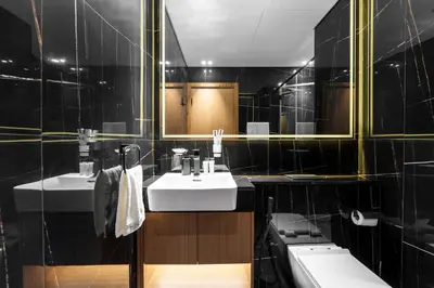 a bathroom with two sinks and a mirror at Chic 1-Bedroom in Binghatti House JVC in Dubai