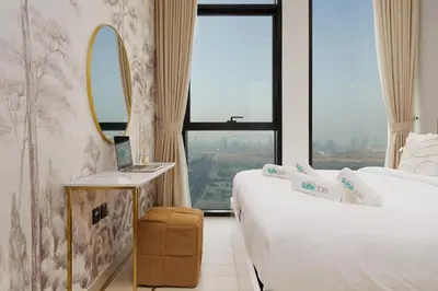 a hotel room with two beds and a window at Chic 1-Bedroom in Binghatti House JVC in Dubai