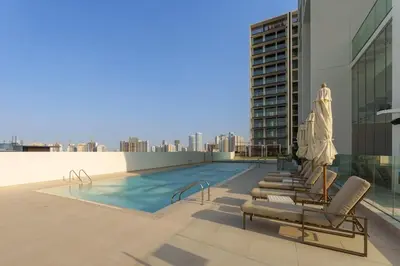 a swimming pool on the roof of a building at Chic 1-Bedroom in Binghatti House JVC in Dubai