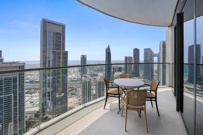 a balcony with a table and chairs and a view of the city at GRANDE SIGNATURE- 2BR Apartment with full Burj Khalifa views in Dubai