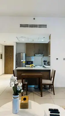 a kitchen with a table and some chairs in a room at MontRose residence Tower A 1BR Apartment in Dubai