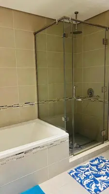 a bathroom with a glass shower with a tub at MontRose residence Tower A 1BR Apartment in Dubai