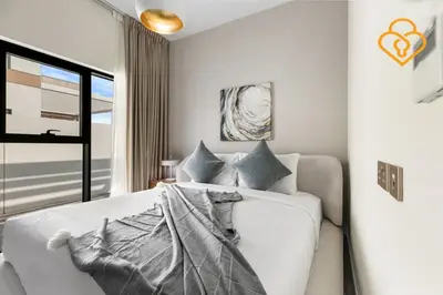 a bedroom with a white bed and a window at Keysplease 4BR, Nanny room, BBQ, Garden, Malibu Beach Access, Damac Hills in Dubai
