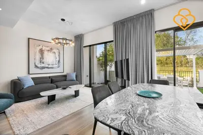 a living room with a table and a couch at Keysplease 4BR, Nanny room, BBQ, Garden, Malibu Beach Access, Damac Hills in Dubai