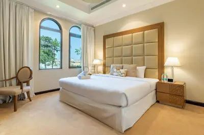 a bedroom with a large white bed and two windows at Exclusive Beachfront Villa with Private Beach Access, Next to the Community Pool, Close to Aquaventure Waterpark, Monorail, and Nakheel Mall, Canal Cove, Palm Jumeirah by Deluxe Holiday Homes in Dubai