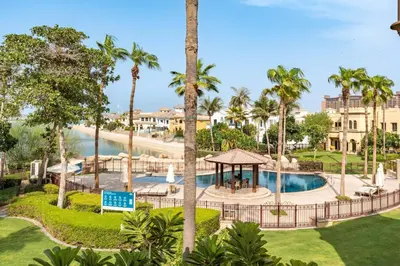 an aerial view of a resort with a pool and palm trees at Exclusive Beachfront Villa with Private Beach Access, Next to the Community Pool, Close to Aquaventure Waterpark, Monorail, and Nakheel Mall, Canal Cove, Palm Jumeirah by Deluxe Holiday Homes in Dubai