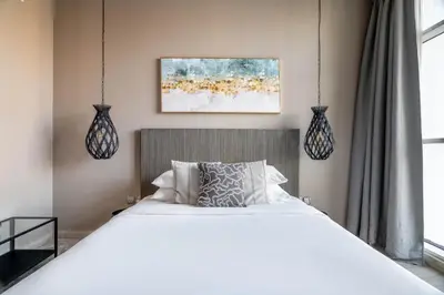 a bedroom with a white bed and two pendant lights at GuestReady - Exquisite living with Marina views in Dubai