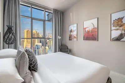a bedroom with a bed and a large window at GuestReady - Exquisite living with Marina views in Dubai
