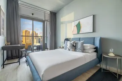 a bedroom with a large bed and a large window at GuestReady - Exquisite living with Marina views in Dubai