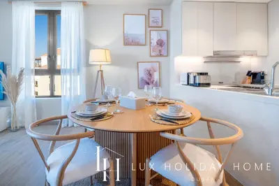 a dining room table with two chairs and a kitchen at LUX The La Mer Infinity View - Luxury Boho Suite 1 in Dubai