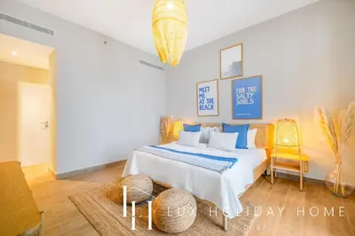 a bedroom with a bed with blue pillows at LUX The La Mer Infinity View - Luxury Boho Suite 1 in Dubai