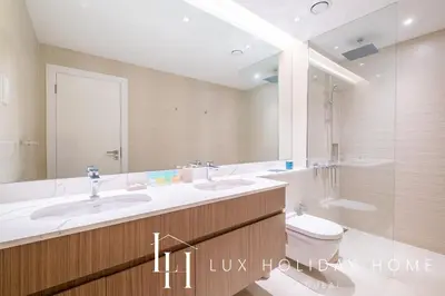 a bathroom with a sink and a toilet and a mirror at LUX The La Mer Infinity View - Luxury Boho Suite 1 in Dubai