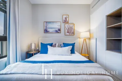 a bedroom with a large bed with blue pillows at LUX The La Mer Infinity View - Luxury Boho Suite 1 in Dubai