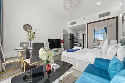 a bedroom with a large bed and a living room at Stylish Studio Close To Metro at Pearlz by Danube in Dubai