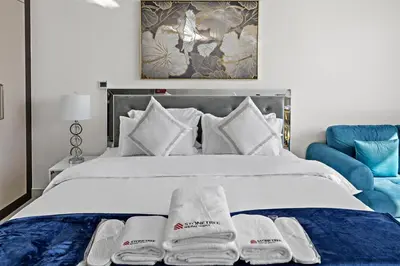 a bedroom with a white bed with towels on it at Stylish Studio Close To Metro at Pearlz by Danube in Dubai
