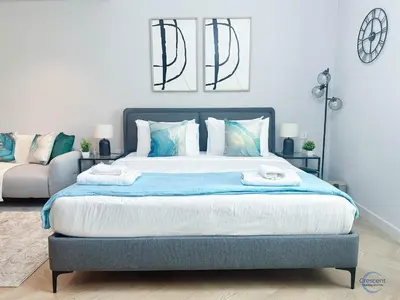 a bedroom with a large bed with two towels on it at Modern Studio in Business Bay Capital Bay Tower in Dubai