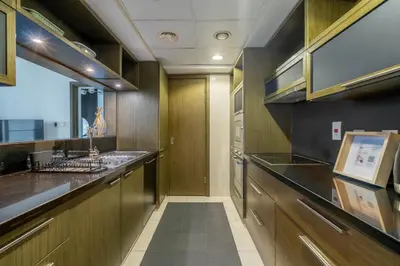 a large kitchen with wooden cabinets and a sink at GuestReady - Downtown charm with skyline views in Dubai