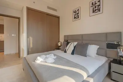 a bedroom with a large bed with white flowers on it at Downtown Luxury - Elegant 1-Bedroom Apartment - 5 Minutes Walk to Dubai Mall in Dubai