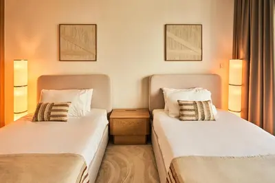 a hotel room with two beds and two lamps at Paramount - Luxury 2BR Apartments with Burj and Sea Views - Access to the Infinity Pool on 64th Floor in Dubai