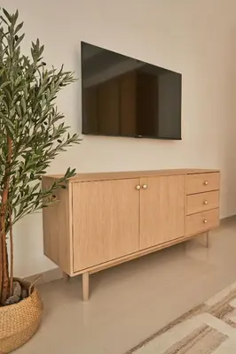 a wooden cabinet with a television on a wall at Paramount - Luxury 2BR Apartments with Burj and Sea Views - Access to the Infinity Pool on 64th Floor in Dubai