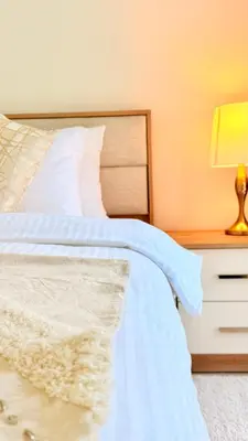 a bedroom with a white bed and a nightstand at One bedroom apartment brand new Dubai Hills ultra luxury furniture in Dubai