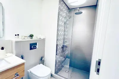 a bathroom with a shower with a toilet and a sink at One bedroom apartment brand new Dubai Hills ultra luxury furniture in Dubai