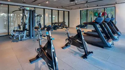 a gym with a bunch of treadms and cardio machines at One bedroom apartment brand new Dubai Hills ultra luxury furniture in Dubai