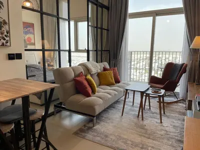 a living room with a couch and a table at Luxe Escape at Dubai Hills in Dubai