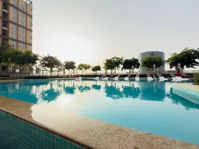 a large pool with blue water in a building at Luxe Escape at Dubai Hills in Dubai