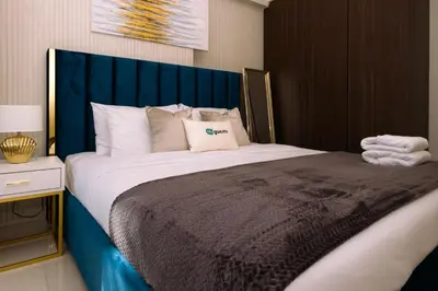a bedroom with a large bed with a blue headboard at HiGuests - Vibrant 1BR in Business Bay in Dubai
