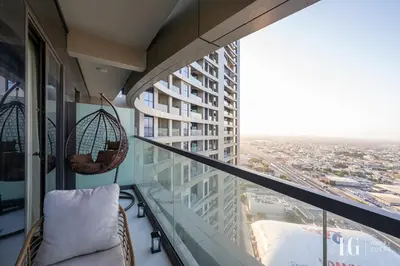 a balcony with a chair and a view of a city at Sky-High Aykon City Studio in Dubai