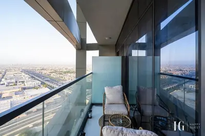 a balcony with two chairs and a view of a city at Sky-High Aykon City Studio in Dubai