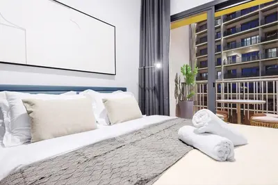 a bedroom with a large bed with white sheets and pillows at Luxury 1BR City View with Balcony Parking & WiFi Near Dining & Downtown in Dubai