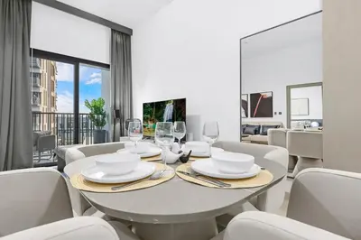 a white dining room with a table and chairs at Luxury 1BR City View with Balcony Parking & WiFi Near Dining & Downtown in Dubai