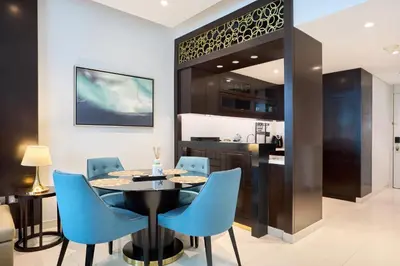 a dining room with a table and blue chairs at Downtown 1BR - 5 minutes to mall - panoramic pool in Dubai