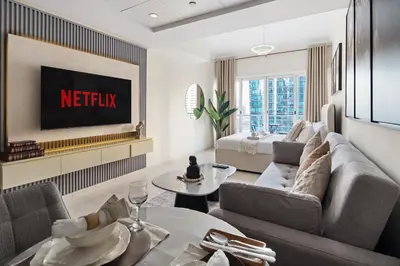 a living room with a couch and a tv at Modern Studio Apartment in Lake View in Dubai