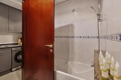 a shower with a glass door in a bathroom at Modern Studio Apartment in Lake View in Dubai