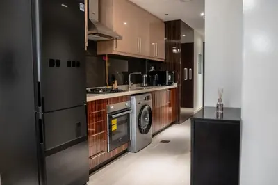 a kitchen with a refrigerator and a dishwasher at Clever Guest 002 Elite Downtown in Dubai