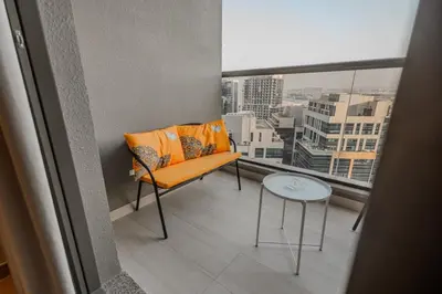 an orange chair and a table on a balcony at Clever Guest 002 Elite Downtown in Dubai