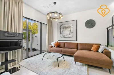 a living room with a couch and a table at Keysplease 4BR, Garden BBQ, Malibu Beach Access, Damac Hills 40 in Dubai