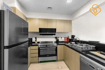a kitchen with a stove and a refrigerator at Keysplease 4BR, Garden BBQ, Malibu Beach Access, Damac Hills 40 in Dubai