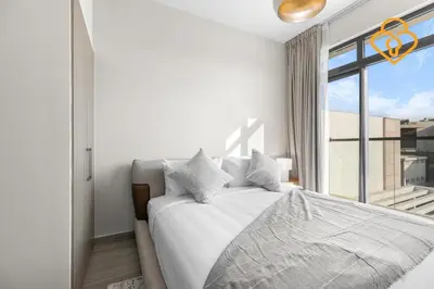 a white bedroom with a bed and a window at Keysplease 4BR, Garden BBQ, Malibu Beach Access, Damac Hills 40 in Dubai