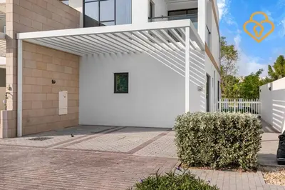 a white garage with awning on the side of a building at Keysplease 4BR, Garden BBQ, Malibu Beach Access, Damac Hills 40 in Dubai
