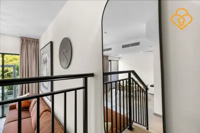 a staircase in a house with a clock on the wall at Keysplease 4BR, Garden BBQ, Malibu Beach Access, Damac Hills 40 in Dubai