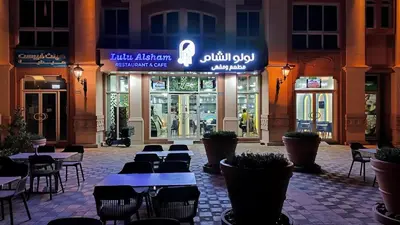 a restaurant with tables and chairs in front of a building at Huge Exclusive Comfortable Studio With Canal View! in Dubai
