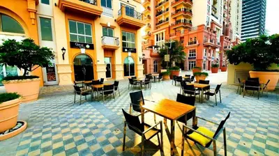 an outdoor patio with tables and chairs and buildings at Huge Exclusive Comfortable Studio With Canal View! in Dubai